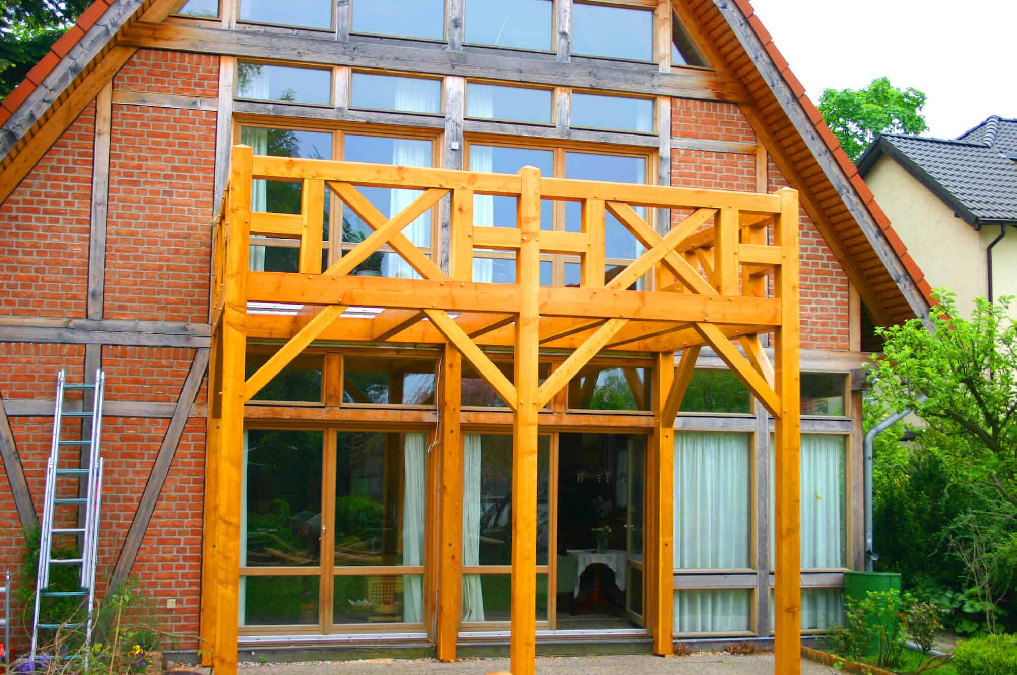 Holzbalkon als Fachwerkkonstruktion in Douglasie mit darunterliegender Terrasse